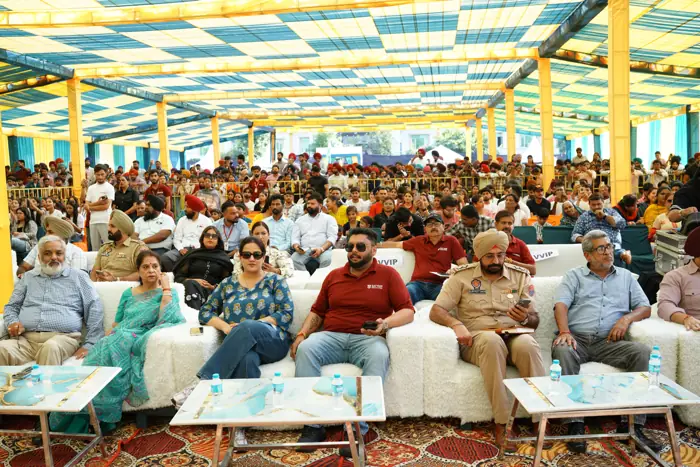 A packed audience under the festival canopy